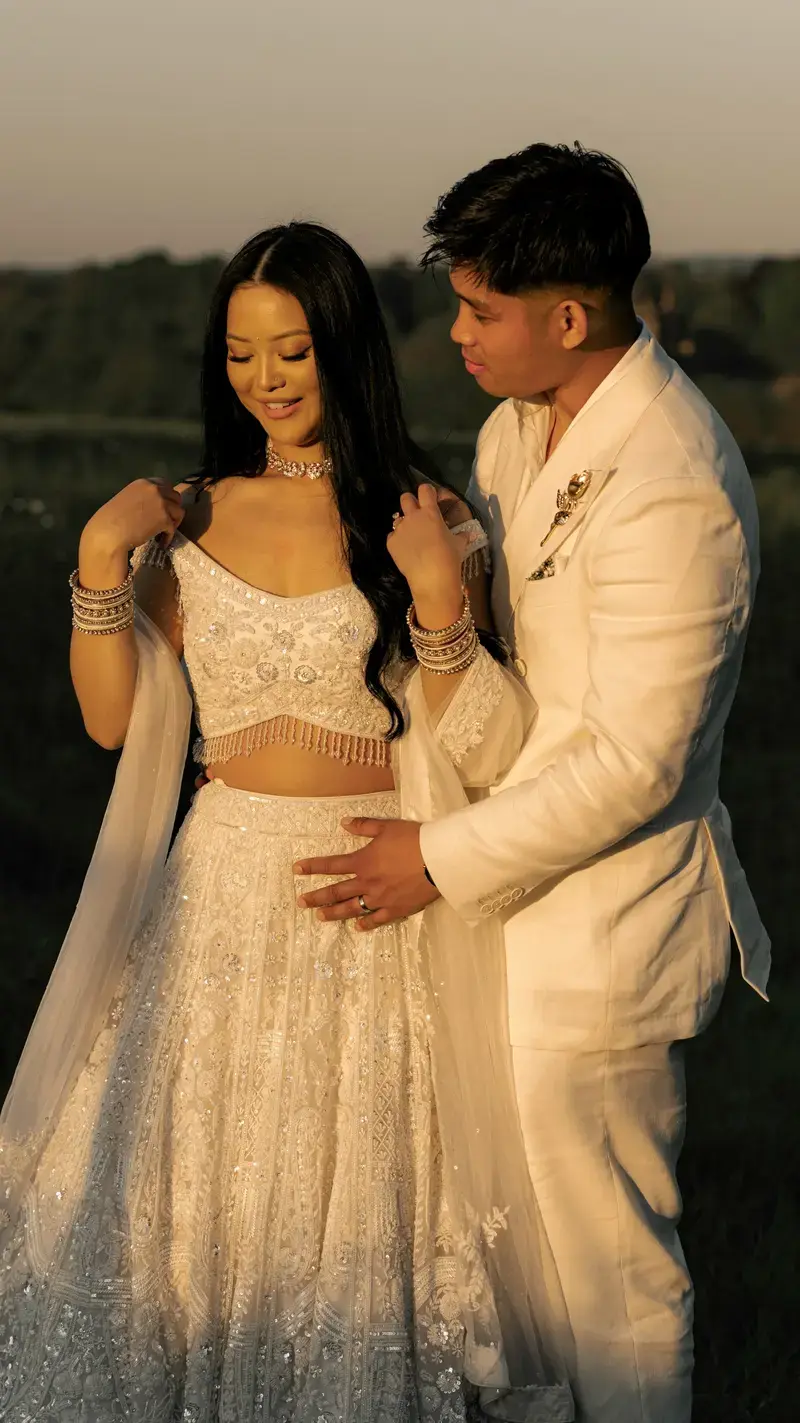 The couple in white wedding attire posing together